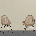 Minimalist Rattan Single Chairs with Black Metal Legs Against Beige Wall and Gray Floor