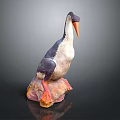 Gray And White Bird Sculpture With Orange Beak Feet On Colorful Rock Base