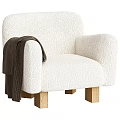 Cozy White Bouclé Accent Chair With Wooden Legs And Brown Blanket On Armrest