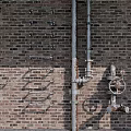 Industrial Pipes Mounted on Exposed Brick Wall with Valves and Metal Fittings