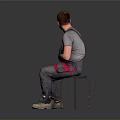 Man Sitting On Chair In Gray T Shirt And Gray Overalls With Red Details Beige Shoes On Gray Gradient Background