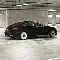 Black Bugatti Car Parked In Spacious Parking Garage With Concrete Pillars And Ceiling Lights