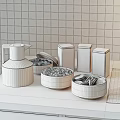 Beige Water Jug Colorful Tea Tins and Bowls with Candies Chocolate Bars on Kitchen Counter