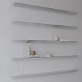 White Wall Featuring Floating Shelves With Minimalist Accessories Small Jars Bowls Striped Shadows