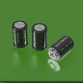 Household Batteries Black Cylindrical With White Text And Logo Placed On Green Surface