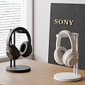 Sony Black and White Headphones Displayed on Stands in Modern Desktop Setup
