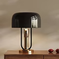 Black Table Lamp With Gold Base And Metal Stand On Wooden Tabletop With Red Fruits