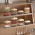 Glass Spice Jars with Colored Lids on Wooden Shelf Holding Various Seasonings