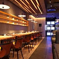 Modern Restaurant Interior With Wooden Partitions Pendant Lights Hanging Plants Round Dining Table And Chairs