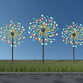 Three Colorful Windmill Shaped Architectural Structures Standing On Green Grassland Under Blue Sky