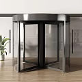 Modern Revolving Door with Glass Panels and Metal Frame in Interior Space with Plant