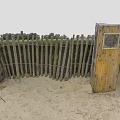 Wooden Fence Made Of Poles And Wire On Sandy Ground