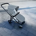 Modern Gray Patterned Stroller With Black Frame On Outdoor Paved Ground