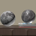 Glowing Moon Shaped Decorative Lamps On Wooden Shelf With Stacked Books