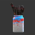 Paintbrushes in Colorful Vase With Blue Red White Paint Splatters On Dark Background