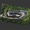Ancient Stone Castle With Multiple Towers Surrounded By Lush Green Trees And Grass