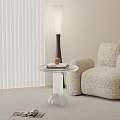 Transparent Modern Side Table With Round Top Beige Patterned Sofa Floor Lamp And White Blinds