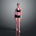 Woman in Black Sports Bra and Black Shorts Standing Barefoot on Dark Background