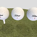 Three Titleist 1 Golf Balls As Sports Equipment Placed On Grass With Tee