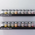 Neatly Arranged Glass Spice Jars with Labels on Black Kitchen Shelves