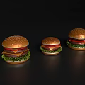 Three Different Sizes of Delicious Hamburgers Displayed on Black Background