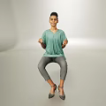 Casual Woman Sitting in Light Green V Neck T Shirt Gray Skinny Pants High Heels Simple Background