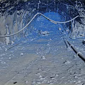 Underground Mine Tunnel Interior With Rock Walls Dirt Ground And Hanging Cables Pipes