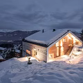 Snowy Hillside Modern Detached Villa Illuminated With Garage And Surrounding Trees