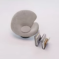 Gray Upholstered Lounge Chair With Curved Shape And Book Holder With Books