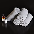 Soft Gray Rolled Towels With Natural Bath Products On Black Surface