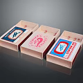 Three Vintage Matchboxes With Colorful Labels And Distinct Designs On Reflective Surface
