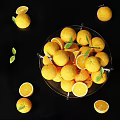 Fresh Oranges in Glass Bowl with Slices and Green Leaves on Black Surface