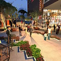 Vibrant Commercial Street With Pedestrians Shops Greenery Outdoor Seating And Evening Lights
