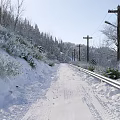 Winter Landscape With Snow Covered Trees Pathway Lake And Distant Mountains Clear Blue Sky