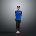 Woman Standing Barefoot In Blue Polo Shirt And Black Pants Against Gray Background