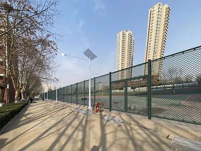 School Playground With Green Chain Link Fence Solar Street Lights Sidewalk And Blue Sky 3d model