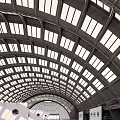 Modern Open Exhibition Hall with Arched Glass Roof White Walls and Displayed Artworks