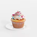 Delicious Cupcake with Swirled Vanilla Frosting and Colorful Sprinkles on White Plate Against White Background