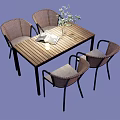 Wooden Outdoor Table with Four Rattan Chairs and a Book with Plant Vase on Top