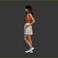 Woman in Orange Tank Top White Skirt and White Shoes Standing Against Gray Background