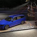 Blue Mercedes-Benz Car on Illuminated Display Platform With Stage Lights And Background Trees