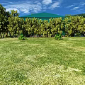 Beautiful Garden Landscape With Green Lawn Trees Mountain View Blue Sky And White Clouds