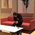 Man Sitting On Red Sofa Holding Mobile Phone With White Table Cup And Box