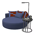Round Blue Single Sofa Featuring Orange And White Patterned Cushions And Small Side Table