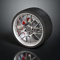 Car Tire With Silver Alloy Wheel Red Brake Calipers And Reflection On Dark Surface