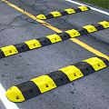 Road Infrastructure Featuring Yellow Black Speed Bumps and Asphalt Traffic Lines