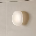 White Round Shaped Wall Lamp Illuminated On Light Colored Tiled Wall