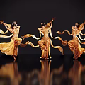 Three Female Dancers With Elaborate Headpieces In Golden Costumes Dancing With Flowing Ribbons