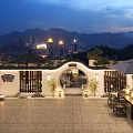 Traditional Chinese Garden Landscape at Night with Lanterns Stone Furniture and Distant City Lights