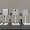 Three White Squat Toilets with Cisterns Gray Trash Bins and Brushes on Dark Gray Floor